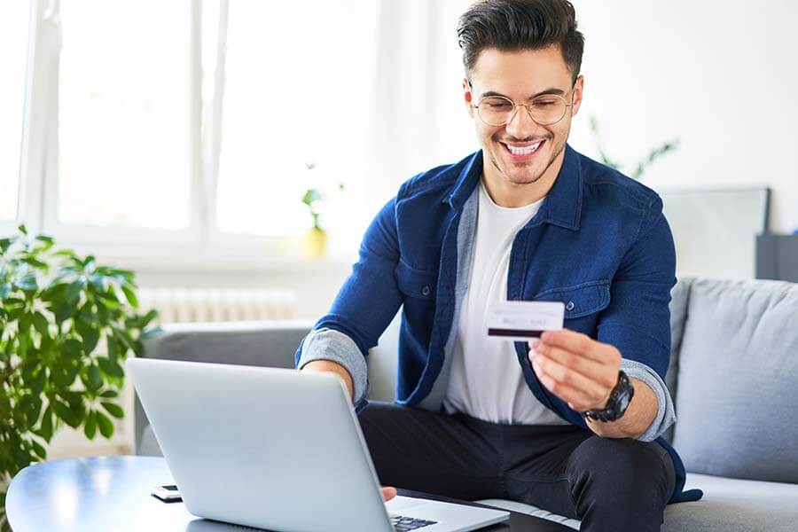 A man using his secured credit card to make a purchase online.